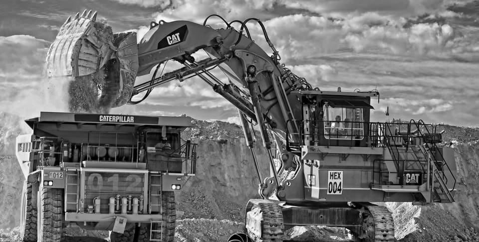 Caterpillar mining excavator loading a haul truck at an open-pit mine